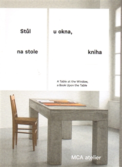 Stůl u okna, na stole kniha